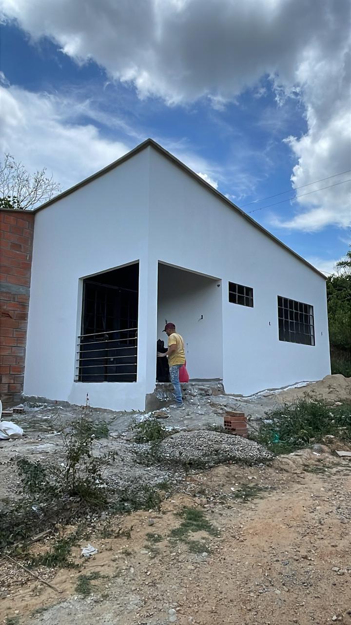 Pared interior con acabado liso de estuco, recibiendo la primera capa de pintura.
